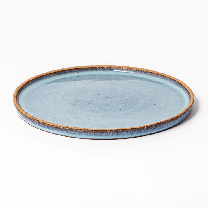 Terracotta blue ceramic dinner plate with rustic brown rim, handcrafted in Japan for daily meals or pasta dishes.