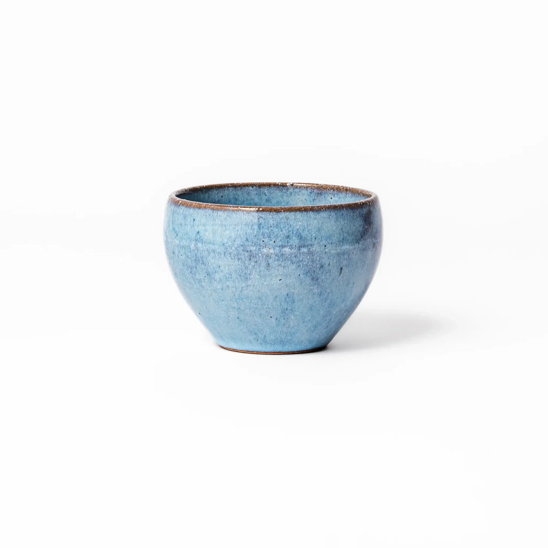 Terracotta blue ceramic tea cup with rustic brown rim, handcrafted in Japan for enjoying tea, coffee, or warm drinks.