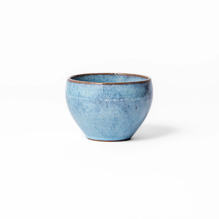 Terracotta blue ceramic tea cup with rustic brown rim, handcrafted in Japan for enjoying tea, coffee, or warm drinks.