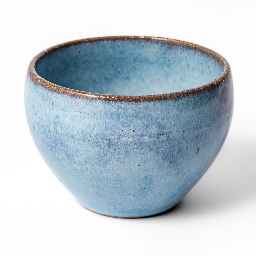Terracotta blue ceramic tea cup with rustic brown rim, handcrafted in Japan for enjoying tea, coffee, or warm drinks.