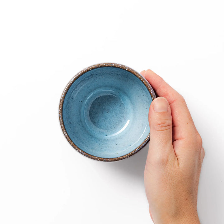 Terracotta blue ceramic tea cup with rustic brown rim, handcrafted in Japan for enjoying tea, coffee, or warm drinks.