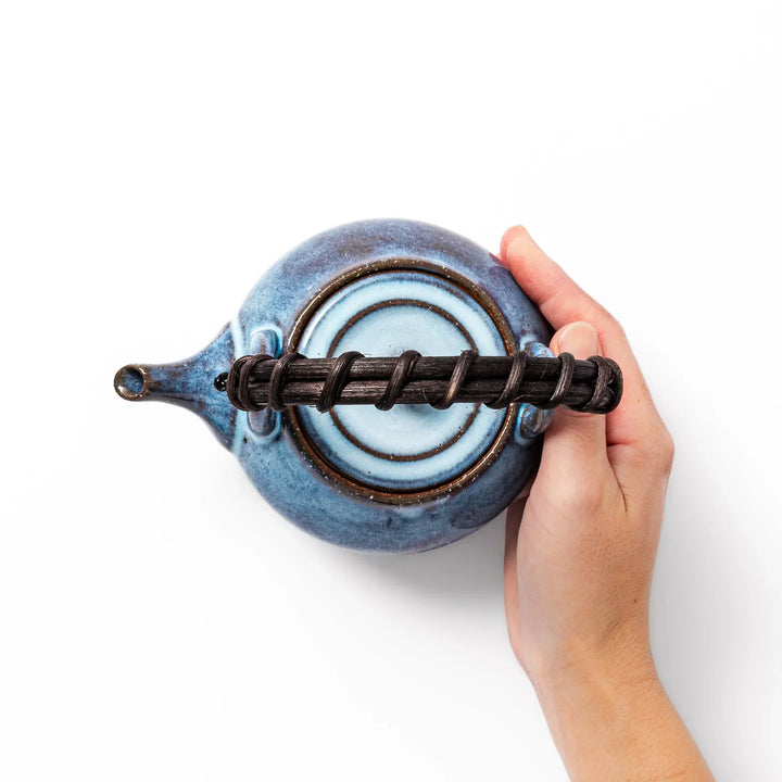 Terracotta blue ceramic teapot with rustic brown rim and metal handle, handcrafted in Japan for daily tea service.