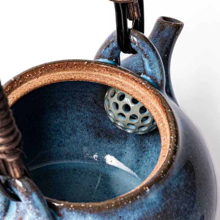 Terracotta blue ceramic teapot with rustic brown rim and metal handle, handcrafted in Japan for daily tea service.