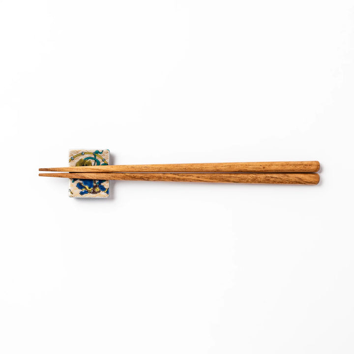 Japanese porcelain chopstick rest featuring the Thunder God design with blue figure and gold wave pattern background.