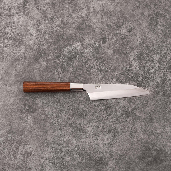Petty knife with polished stainless steel blade and walnut wood handle for precise vegetable slicing and peeling.