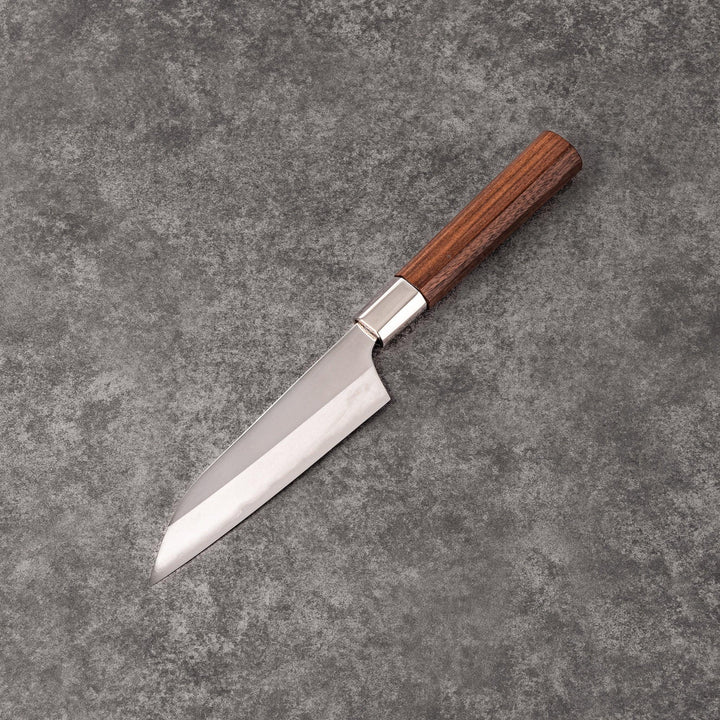 Petty knife with polished stainless steel blade and walnut wood handle for precise vegetable slicing and peeling.