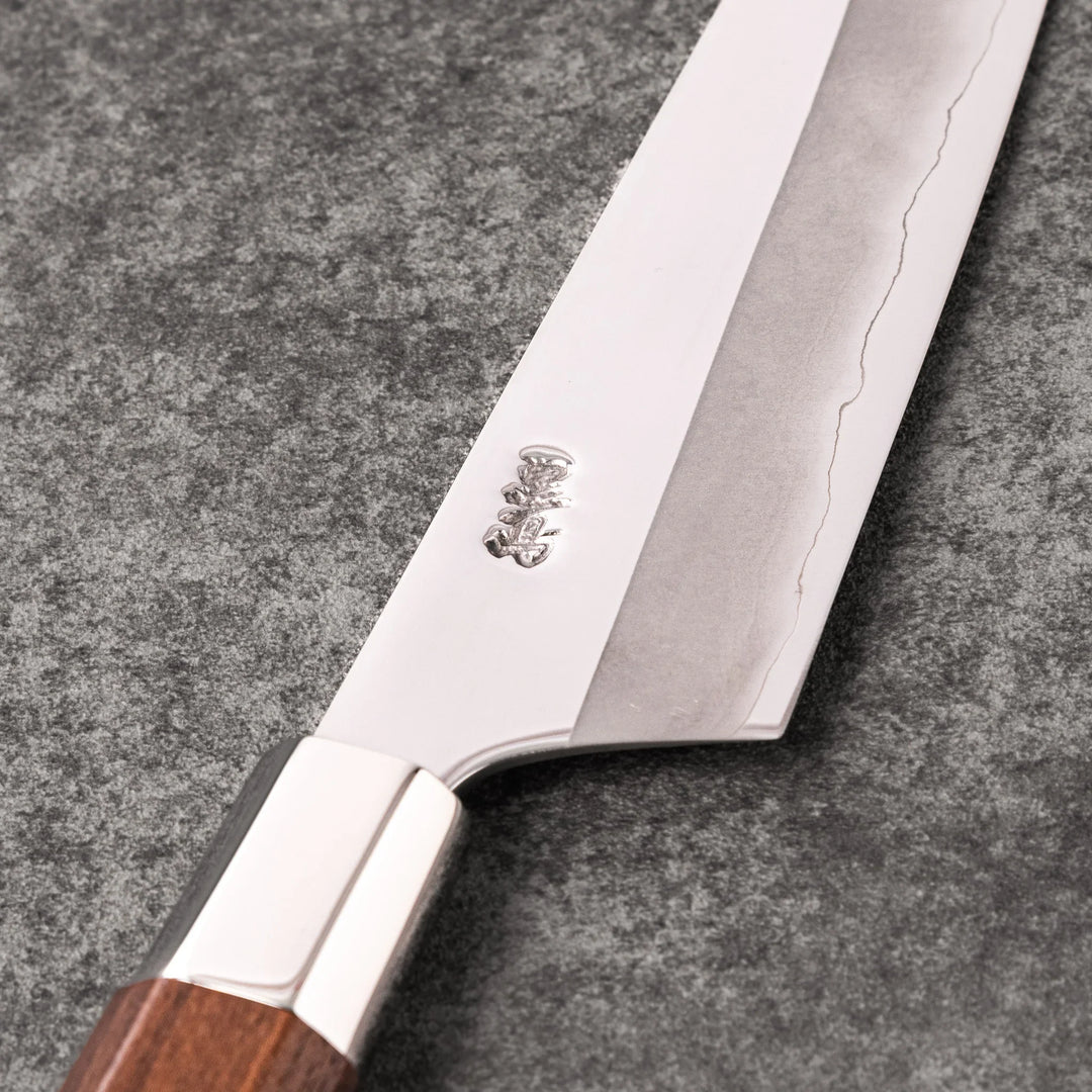 Petty knife with polished stainless steel blade and walnut wood handle for precise vegetable slicing and peeling.