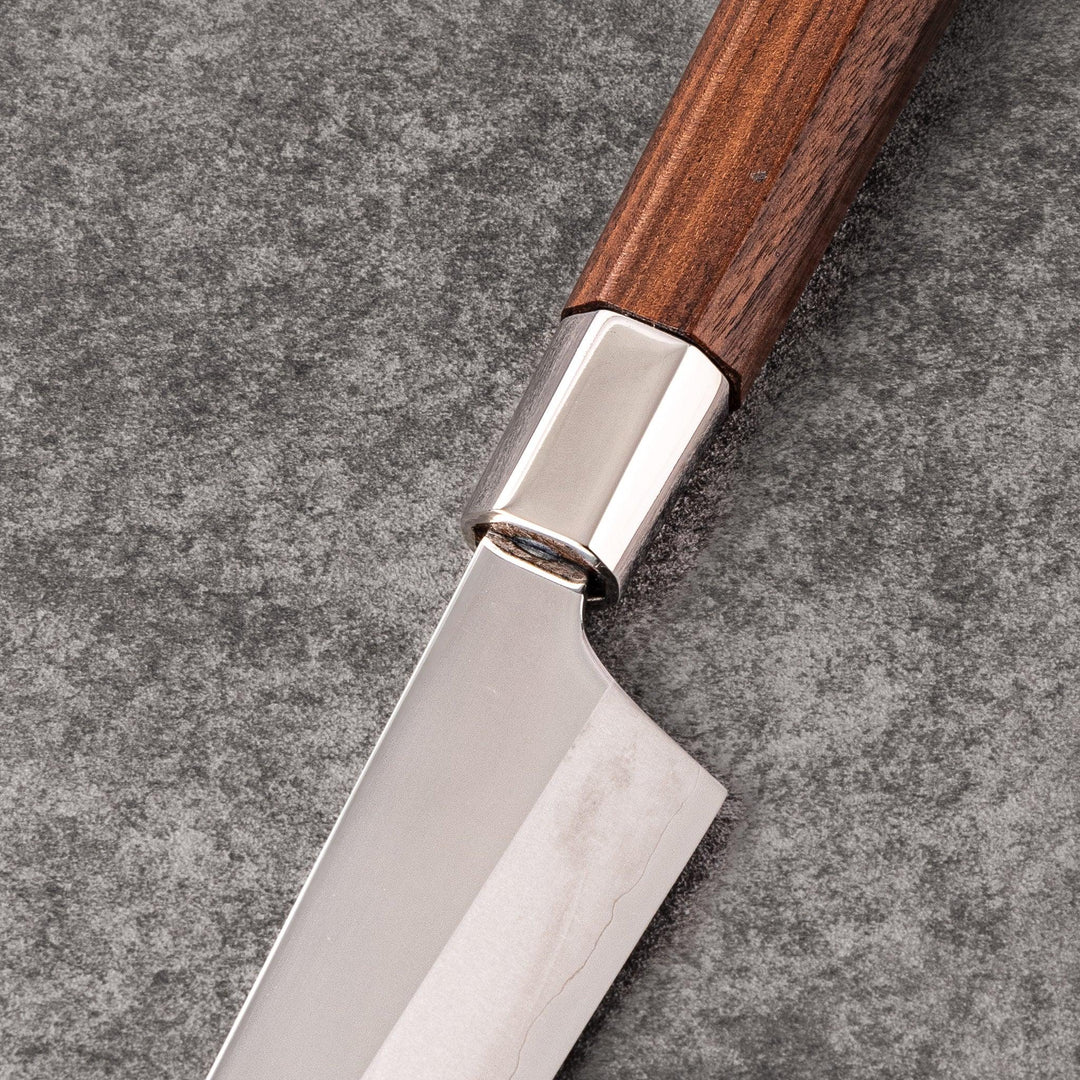 Petty knife with polished stainless steel blade and walnut wood handle for precise vegetable slicing and peeling.
