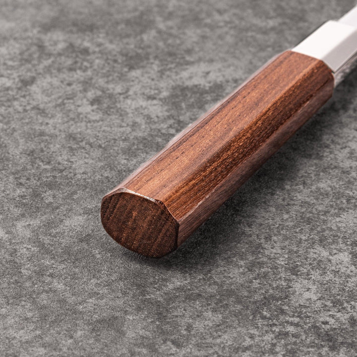 Petty knife with polished stainless steel blade and walnut wood handle for precise vegetable slicing and peeling.