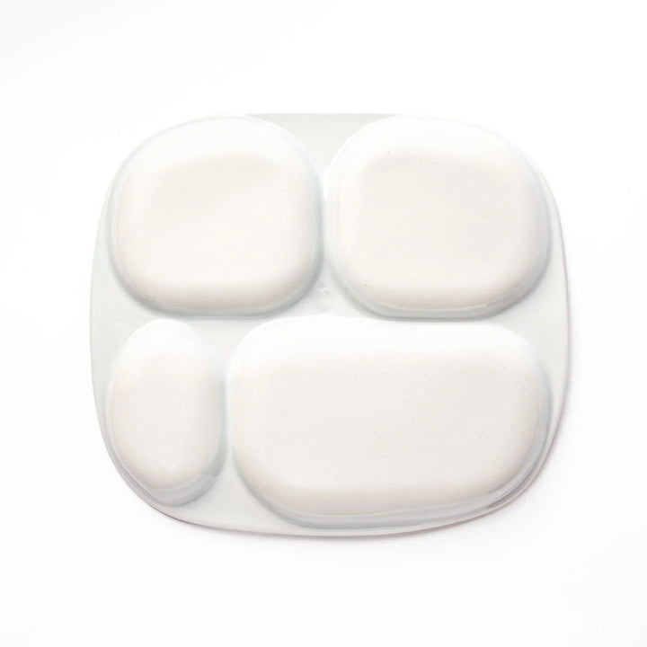 White ceramic kids divided plate with blue triceratops, yellow pterodactyl, red erupting volcano and blue cloud accents