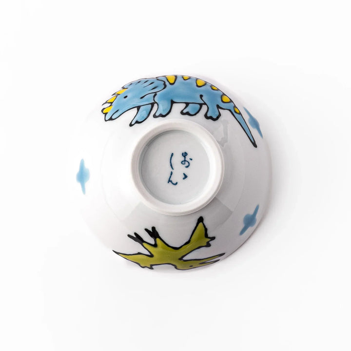 White ceramic kids rice bowl featuring blue triceratops dinosaur with yellow accents and blue cloud motifs