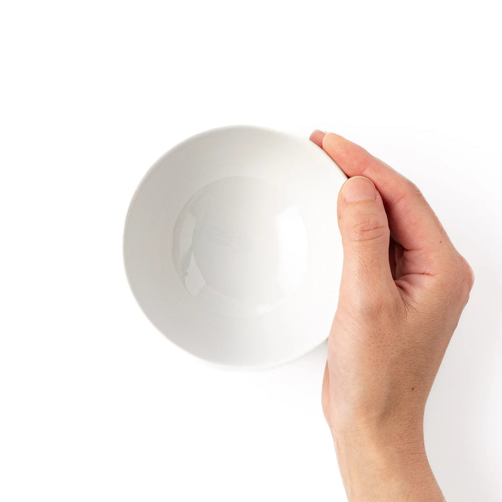 White ceramic kids rice bowl featuring blue triceratops dinosaur with yellow accents and blue cloud motifs