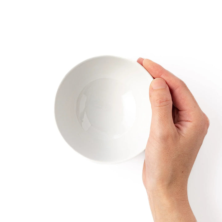 White ceramic kids rice bowl featuring blue triceratops dinosaur with yellow accents and blue cloud motifs
