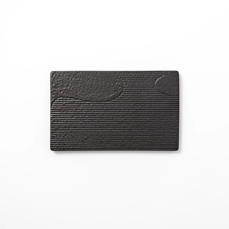 Black Japanese ceramic dinner plate with ridged woodgrain texture and matte gloss finish for modern dining.