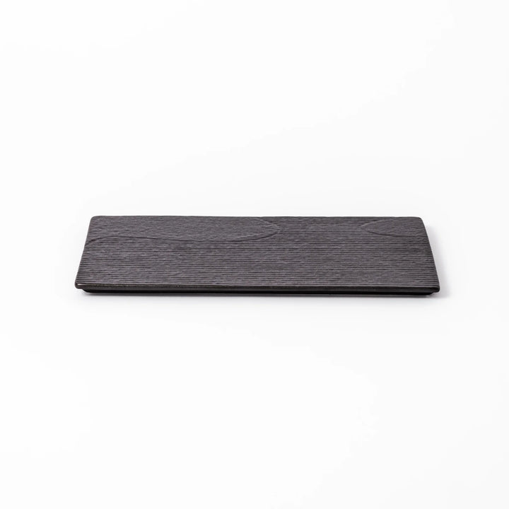 Black Japanese ceramic dinner plate with ridged woodgrain texture and matte gloss finish for modern dining.