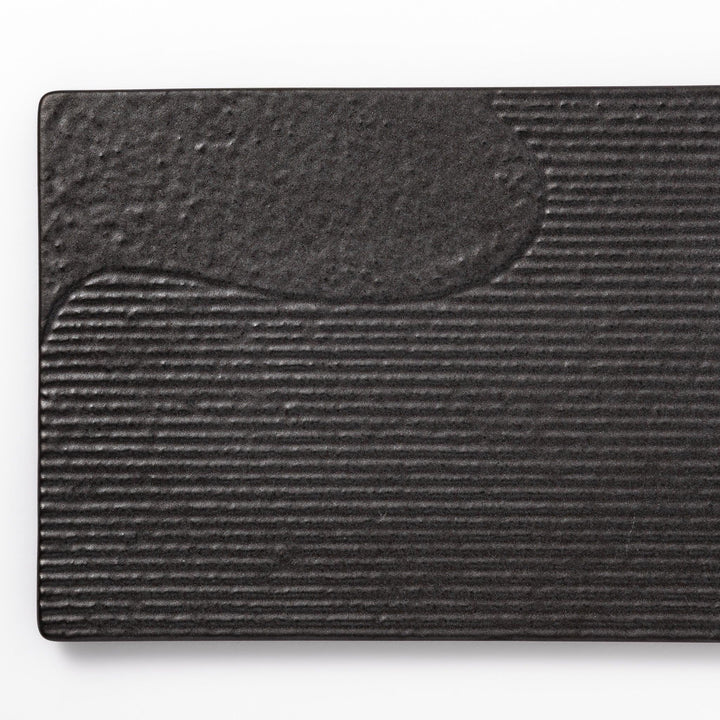 Black Japanese ceramic dinner plate with ridged woodgrain texture and matte gloss finish for modern dining.