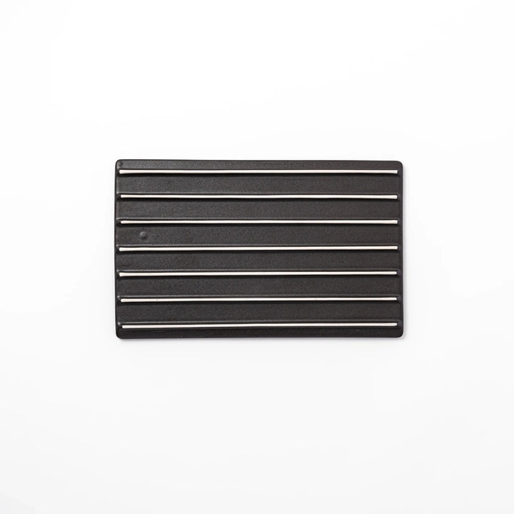 Black Japanese ceramic dinner plate with ridged woodgrain texture and matte gloss finish for modern dining.