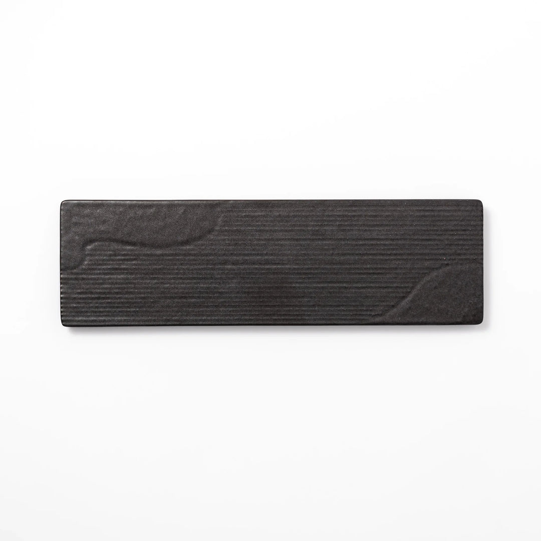Rectangular black Japanese ceramic serving plate with subtle ridged woodgrain texture for modern dining.