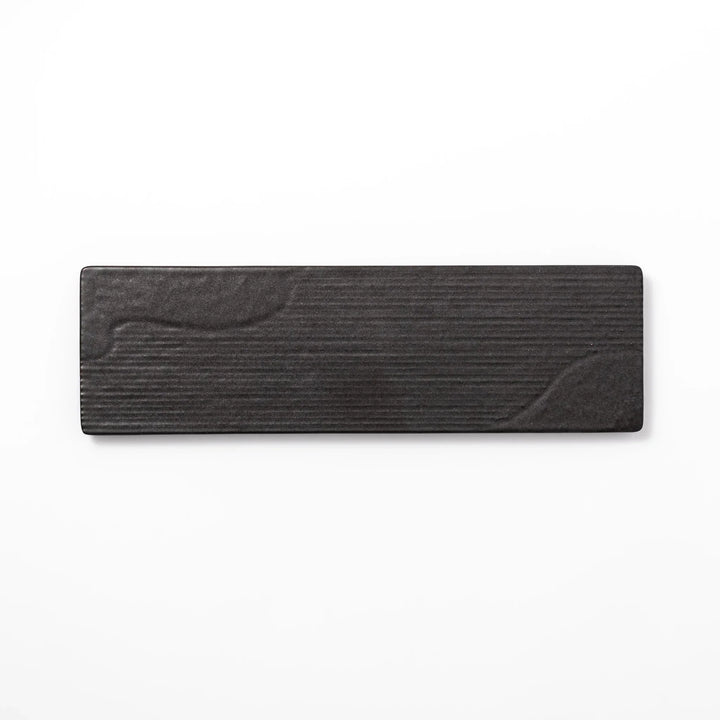 Rectangular black Japanese ceramic serving plate with subtle ridged woodgrain texture for modern dining.
