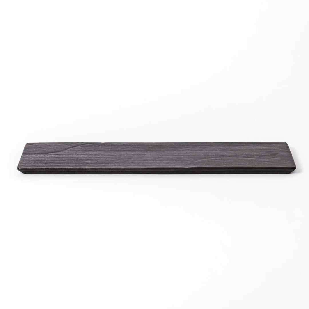 Rectangular black Japanese ceramic serving plate with subtle ridged woodgrain texture for modern dining.