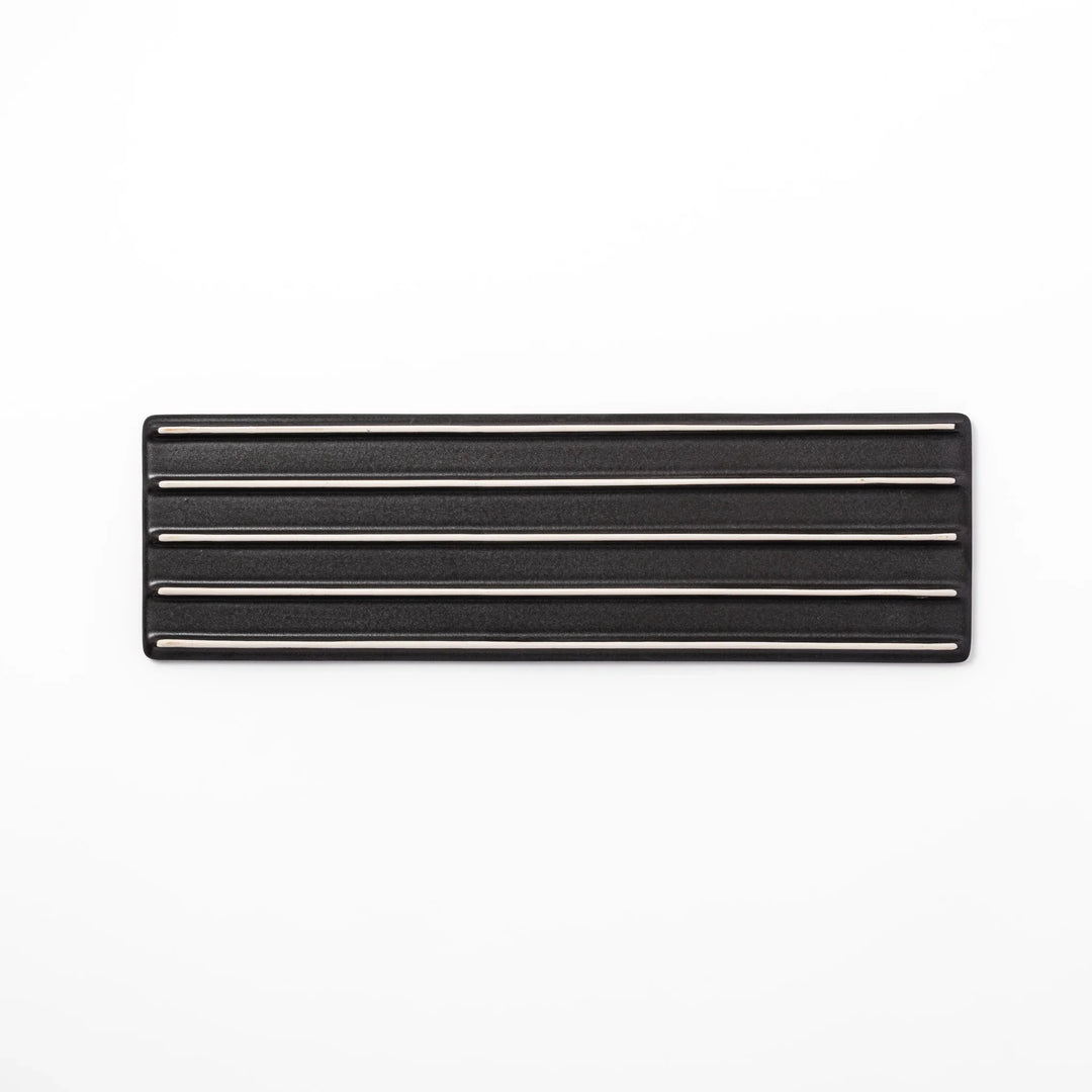 Rectangular black Japanese ceramic serving plate with subtle ridged woodgrain texture for modern dining.