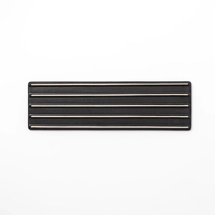Rectangular black Japanese ceramic serving plate with subtle ridged woodgrain texture for modern dining.