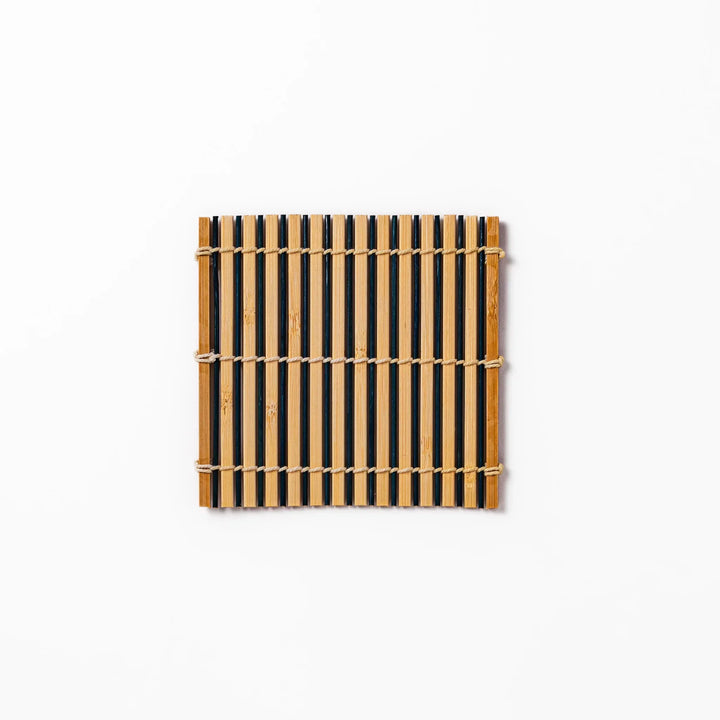 Two tone bamboo coaster with dark and natural slats hand tied with twine for stylish Japanese settings.