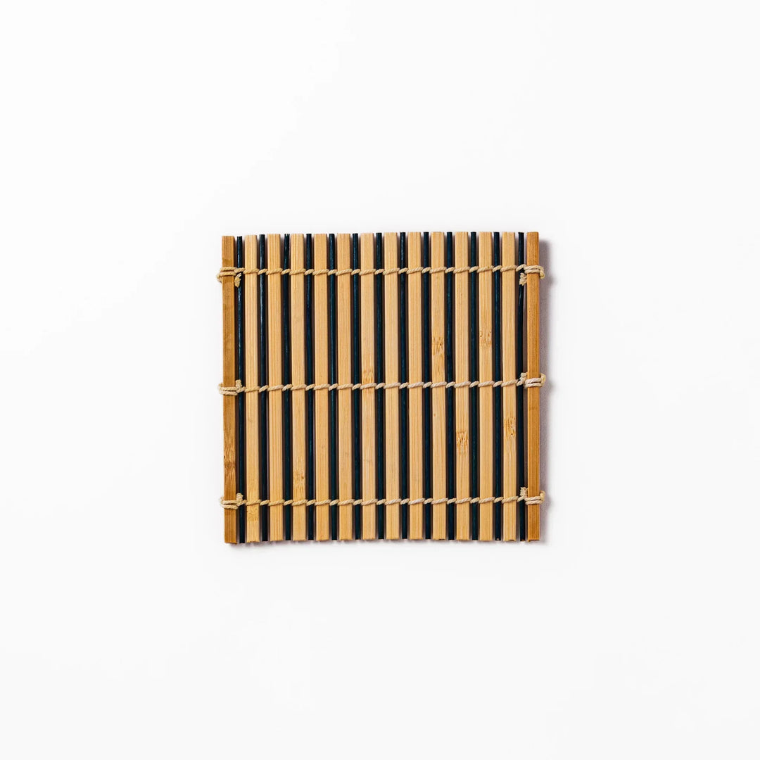 Two tone bamboo coaster with dark and natural slats hand tied with twine for stylish Japanese settings.