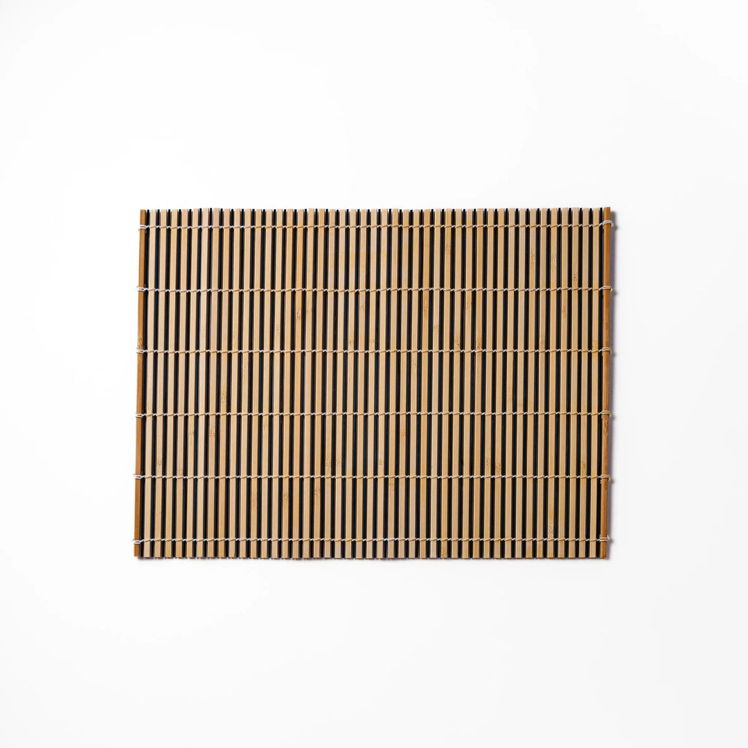 Two tone bamboo table mat with light and dark slats woven with white cord for textured Japanese dining.
