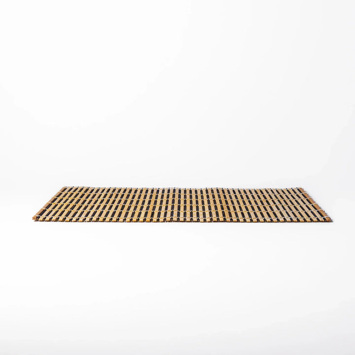 Two tone bamboo table mat with light and dark slats woven with white cord for textured Japanese dining.