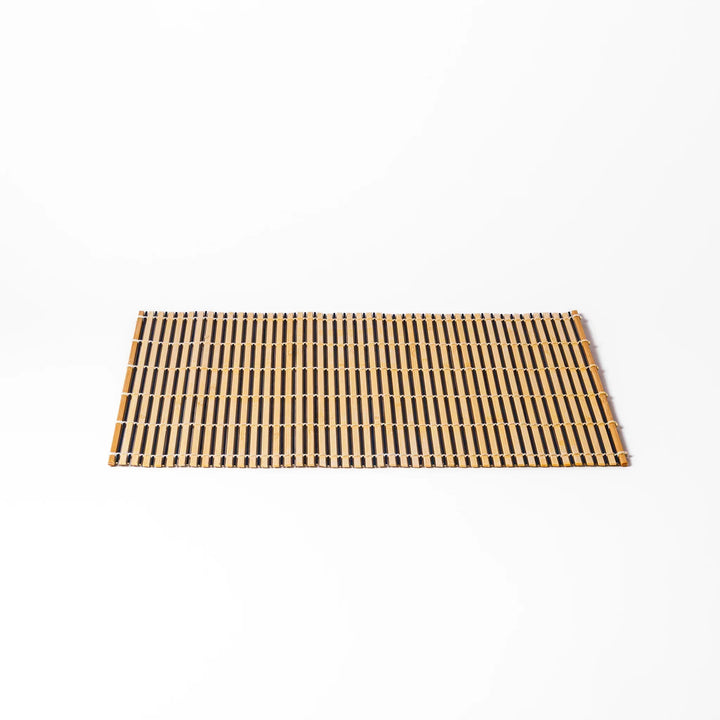 Two tone bamboo table mat with light and dark slats woven with white cord for textured Japanese dining.