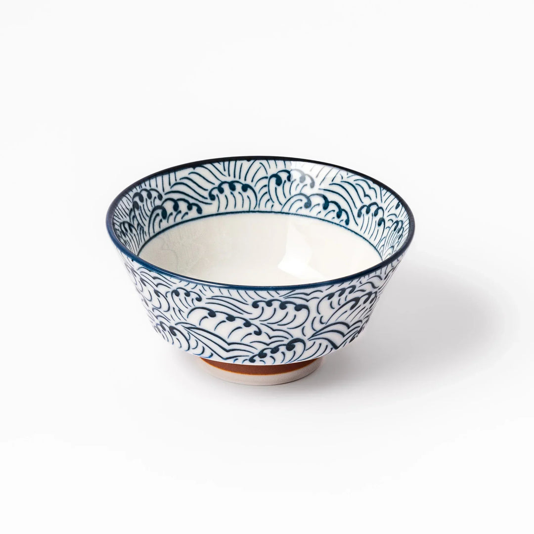 White porcelain rice bowl with navy blue wave ripple pattern and unglazed brown base, photographed on a white background.