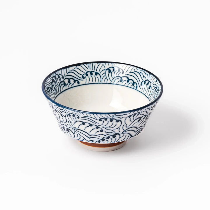 White porcelain rice bowl with navy blue wave ripple pattern and unglazed brown base, photographed on a white background.
