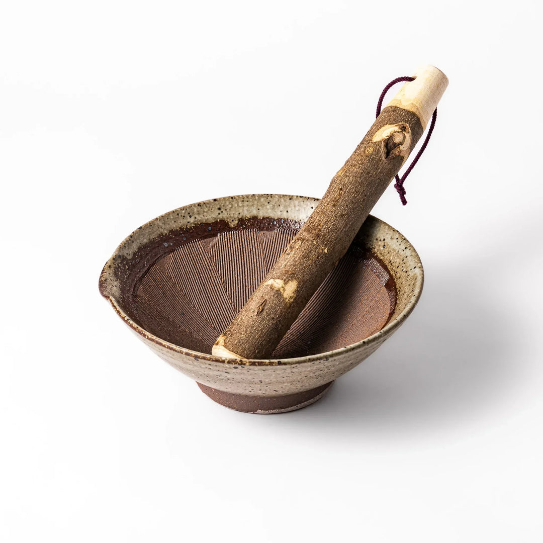 White Karatsu-style mortar paired with a rustic sansho wood pestle, featuring rich brown ridges perfect for grinding seeds.