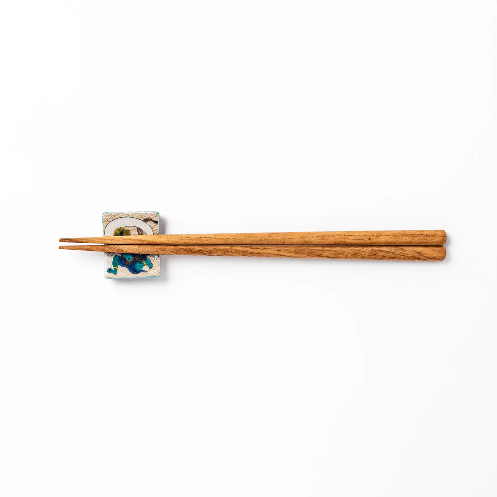 Japanese porcelain chopstick rest featuring the Wind God design with blue figure and gold wave pattern background.