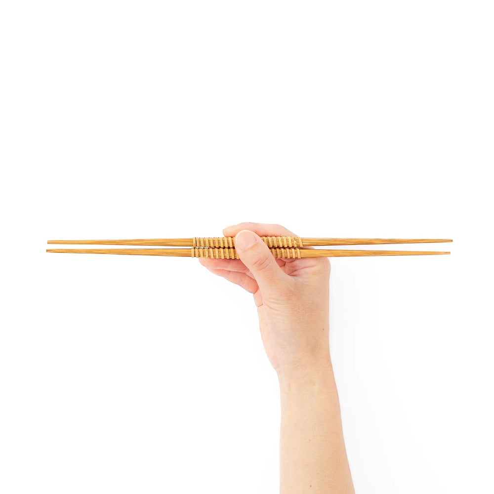 A pair of Japanese bamboo serving chopsticks featuring fine tapered tips on both ends and a textured wrapped center grip