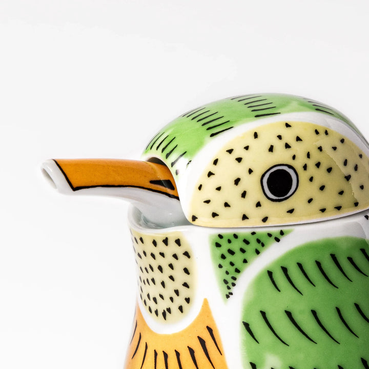 Bird-shaped soy sauce dispenser with green and yellow hand-painted details, adding a playful touch to your table.