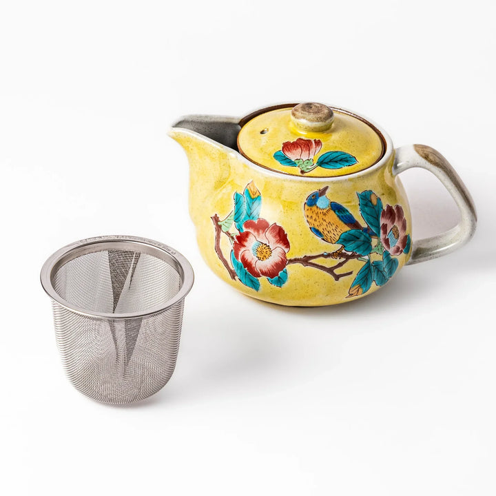 Yellow ceramic teapot with hand painted camellia and bird motif paired with stainless steel strainer.