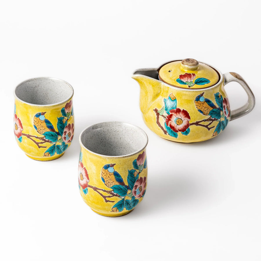 Three piece Japanese ceramic tea set with yellow glaze hand painted camellia flowers and birds on teapot.