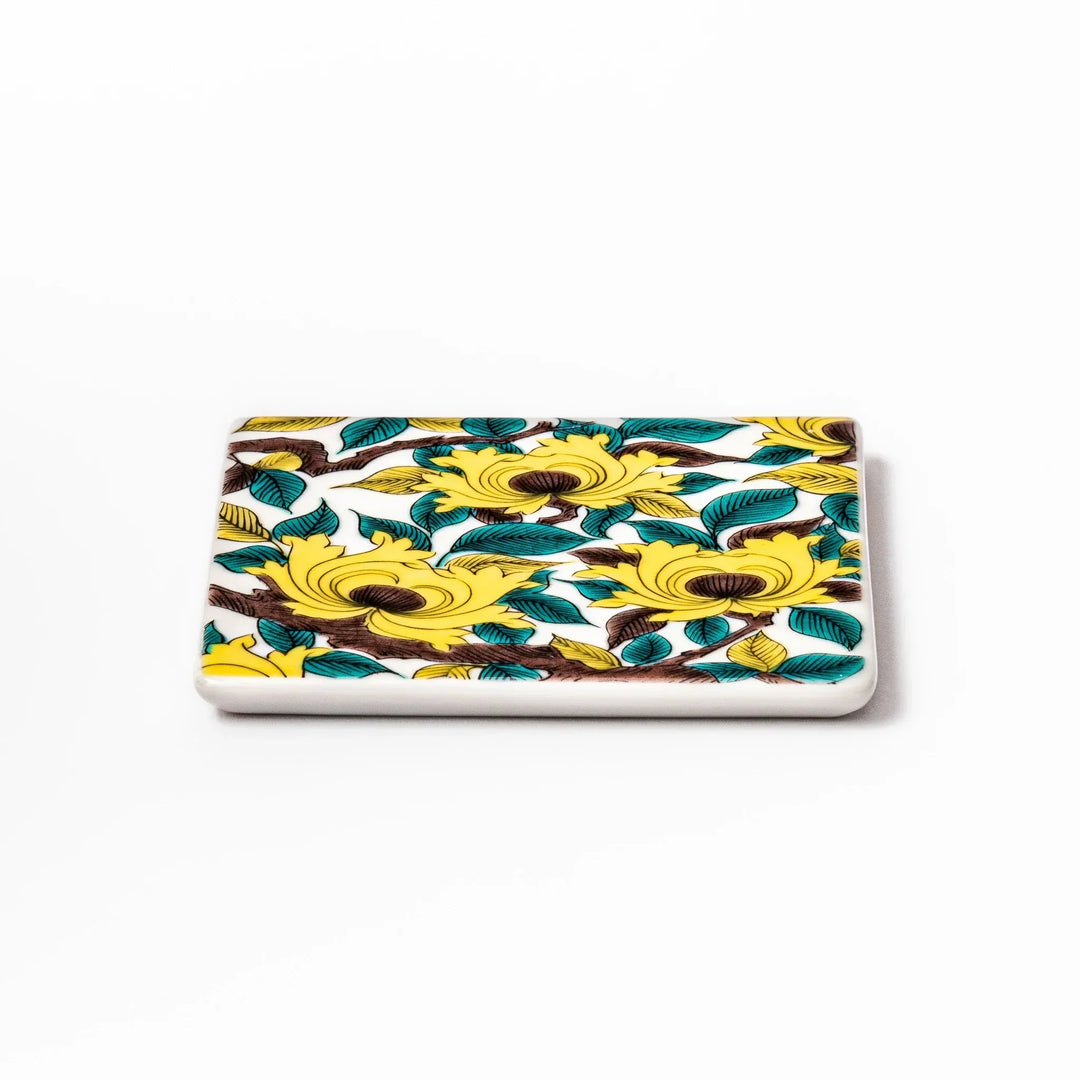 Square Japanese ceramic coaster with yellow peony flowers and teal leaves adding elegance to any table.