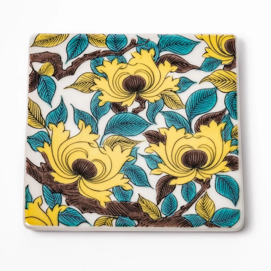 Square Japanese ceramic coaster with yellow peony flowers and teal leaves adding elegance to any table.