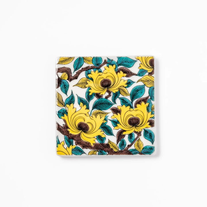 Square Japanese ceramic coaster with yellow peony flowers and teal leaves adding elegance to any table.