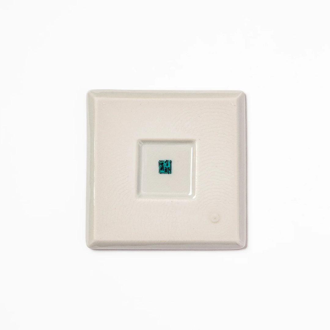 Square Japanese ceramic coaster with yellow peony flowers and teal leaves adding elegance to any table.