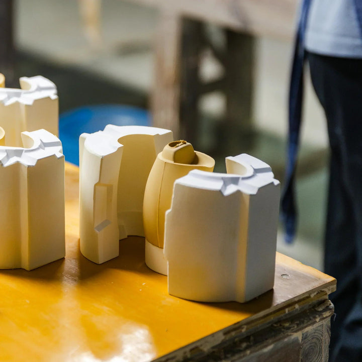 Freshly shaped ceramic vessel revealed as the plaster mold opens during the artisan forming process