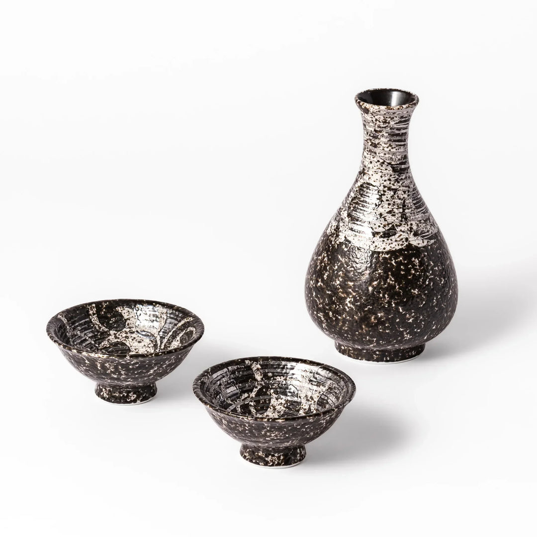 Dark brown and silver Japanese ceramic sake flask with two cups featuring rustic speckled handcrafted look.