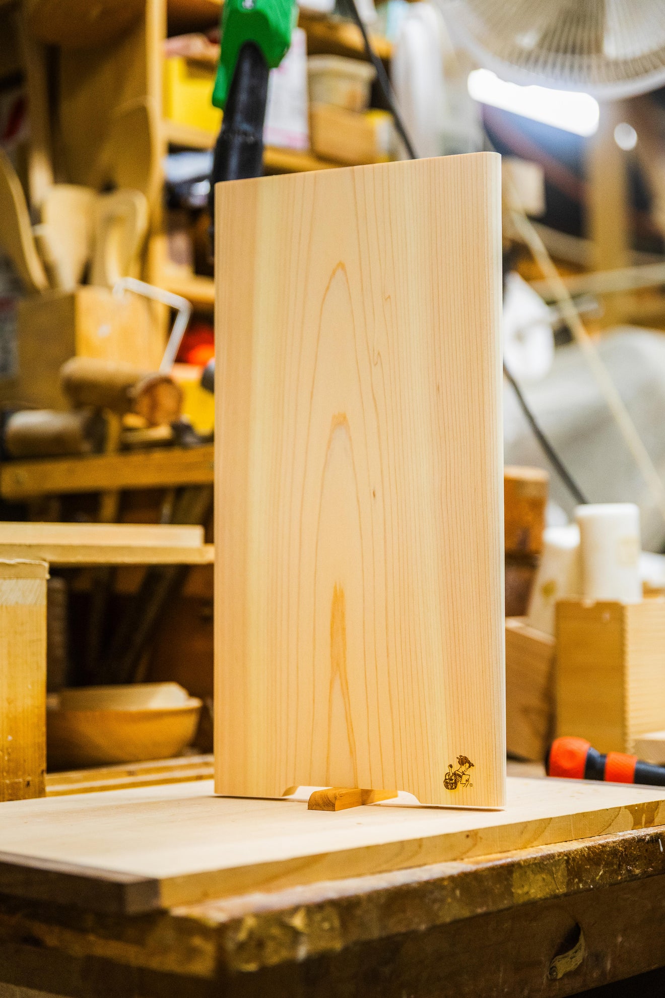 Japanese hinoki cutting board by Tosaryu with natural wood grain displayed in a traditional woodworking workshop