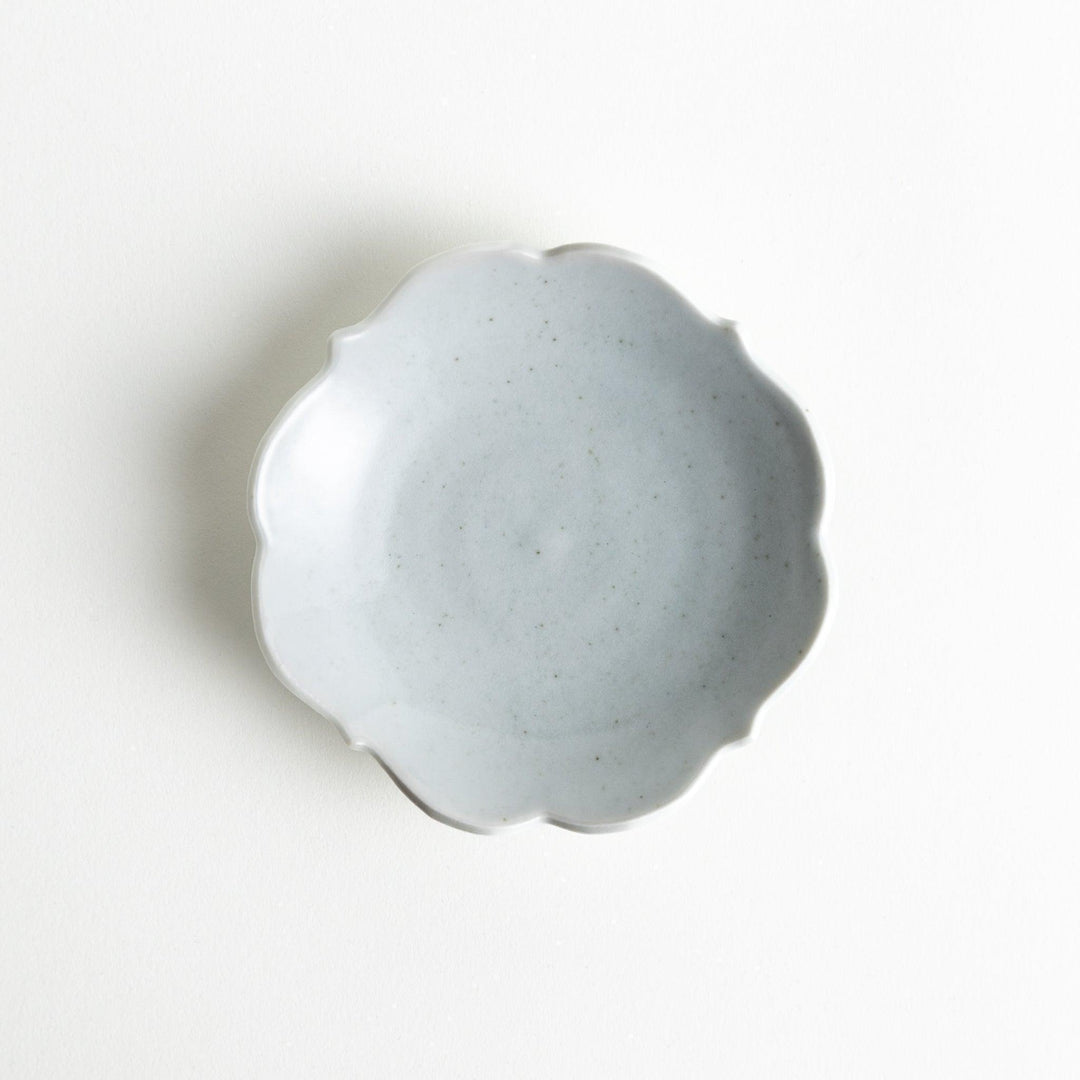 A small ceramic plate with a cloud-like shape, featuring a smooth white finish.