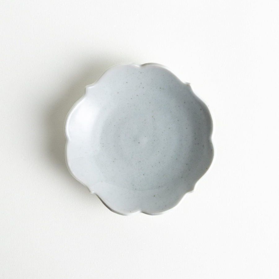 A small ceramic plate with a cloud-like shape, featuring a smooth white finish.