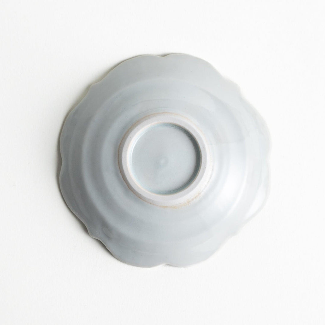 A small ceramic plate with a cloud-like shape, featuring a smooth white finish.