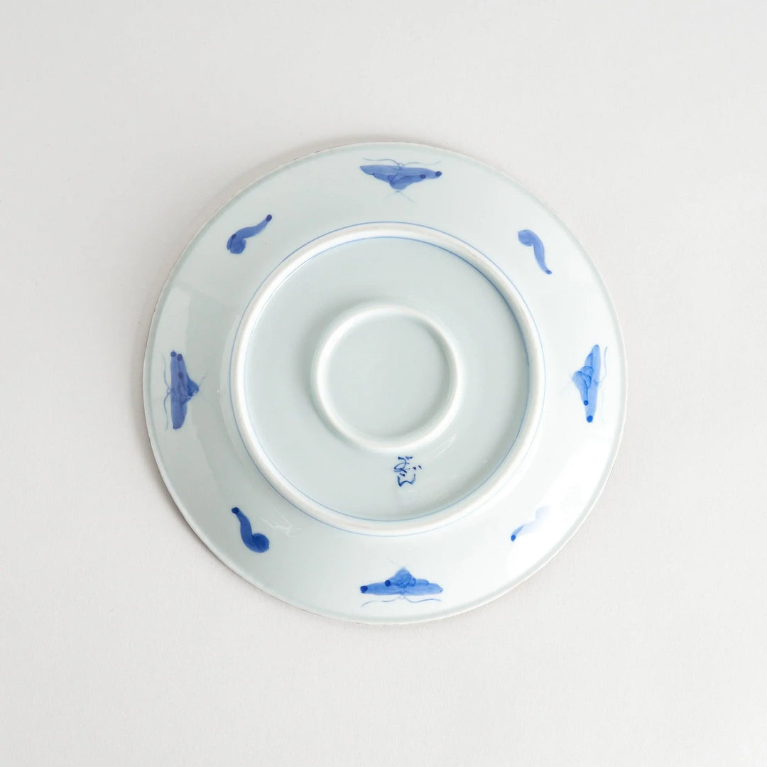 Ceramic plate with intricate blue floral design and bold circular motif framed by copper textured rim.